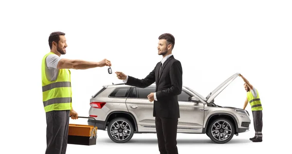 Mechanic Worker Returning Car Keys Businessman Isolated White Background — Stock Photo, Image