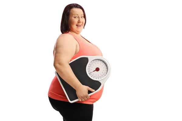 Übergewichtige Frau Trägt Eine Gewichtswaage Und Lächelt Isoliert Auf Weißem — Stockfoto