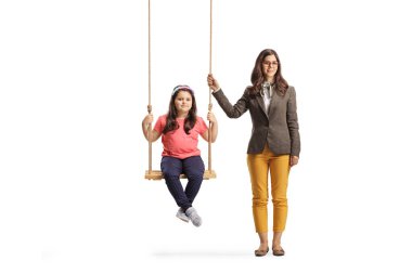 Beyaz arka planda izole edilmiş bir salıncakta bir kızın yanında duran kadın.
