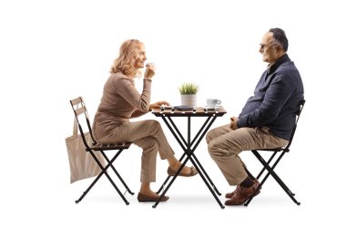 Olgun erkek ve kadın bir masada oturup beyaz arka planda izole edilmiş kahve içiyorlar.