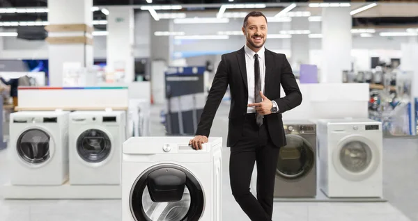 Jonge Professionele Man Een Winkel Leunend Een Wasmachine Wijzend — Stockfoto