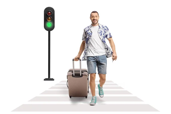 笑顔の男の完全な長さの肖像画歩くと白い背景に隔離された横断歩道でスーツケースを引っ張っ — ストック写真