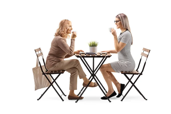 Två Kvinnor Sitter Vid Ett Bord Och Dricker Kaffe Isolerad — Stockfoto
