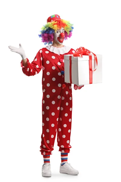 全长的小丑画像 身穿红色服装 手持一个白色背景的礼品盒 — 图库照片