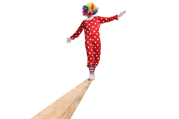 全长的小丑画像 身穿红色服装 在白色背景的横梁上行走 — 图库照片