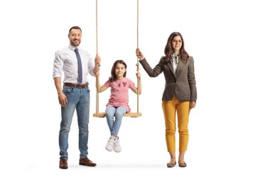 Anne ve baba, beyaz arka planda izole edilmiş bir salıncakta kızlarının yanında duruyor.
