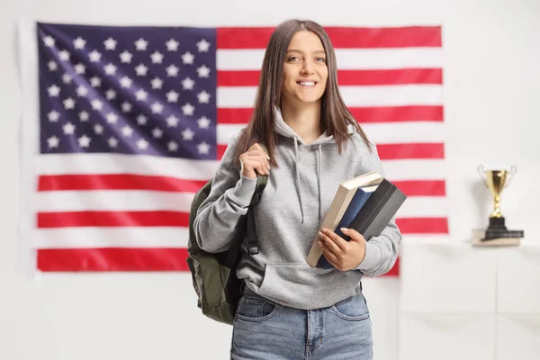 Estudiante Sonriente Sosteniendo Libros Posando Frente Una Bandera Americana —  Fotos de Stock
