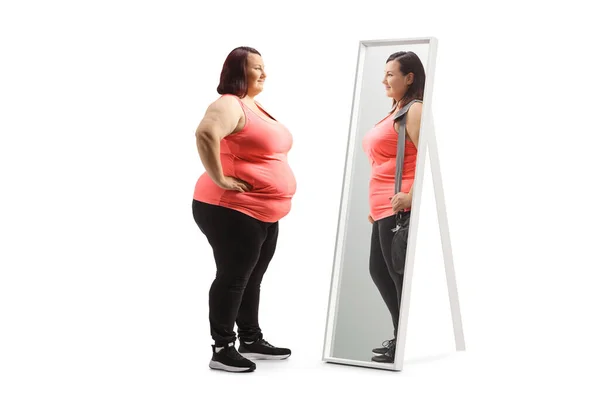 胖女人看着镜子里瘦小的自己 她被白色的背景隔开了 — 图库照片