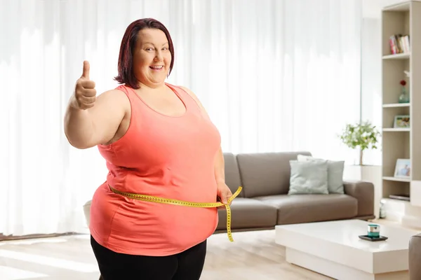 Glückliche Übergewichtige Frau Misst Ihre Taille Hause Und Gestikuliert Mit — Stockfoto