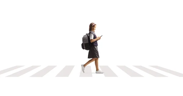 Gadis Sekolah Menyeberangi Jalan Dan Menggunakan Smartphone Terisolasi Pada Latar — Stok Foto