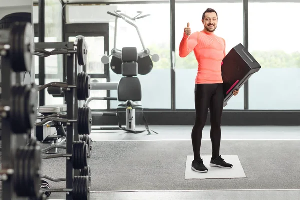 男子有步有氧平台显示大拇指在健身房 — 图库照片
