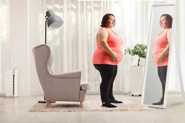 Übergewichtige Frau Hält Ihren Bauch Bei Hom Vor Einem Spiegel — Stockfoto