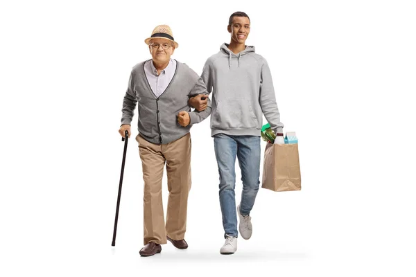 食料品袋を持った若いアフリカ系アメリカ人男性が白人の背景に孤立した老人と歩いている — ストック写真