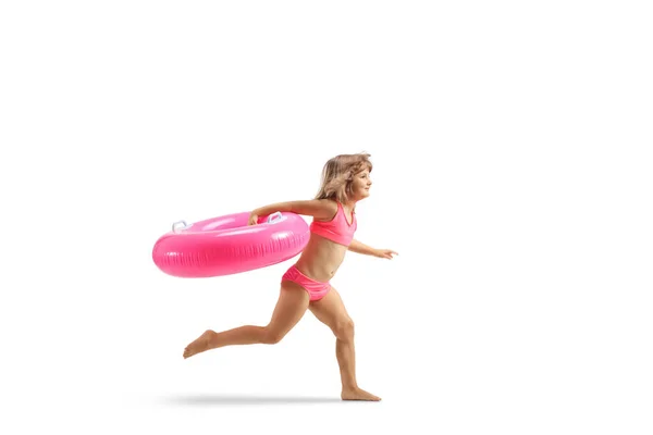 穿着泳衣的小女孩跑着 手里拿着一只粉色橡胶泳圈 与白色背景隔离在一起 — 图库照片