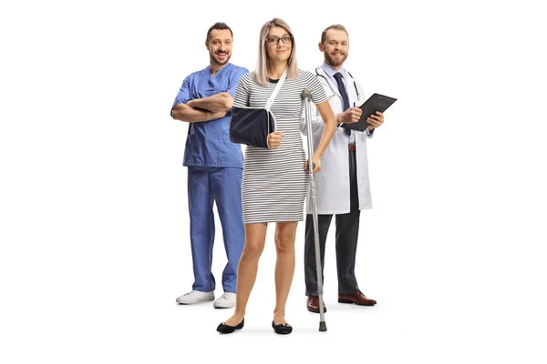 Woman Injured Arm Leg Standing Male Doctors Isolated White Background — Stock Photo, Image