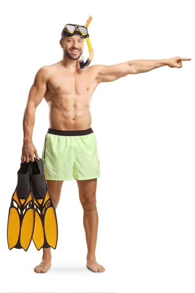 水着姿の若い男の完全な長さの肖像画ダイビングマスクは シュノーケリングのフィンを保持し 白い背景に孤立を指す — ストック写真