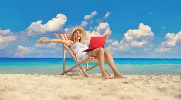 Plaj Sandalyesinde Dizüstü Bilgisayarıyla Oturan Eğlenen Genç Bir Kadın — Stok fotoğraf