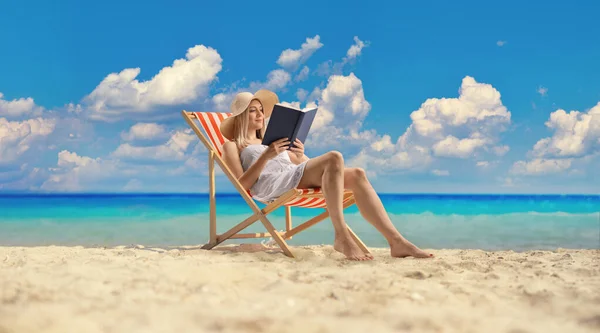 Young Woman White Dress Sitting Beach Chair Reading Book Sea — Stockfoto