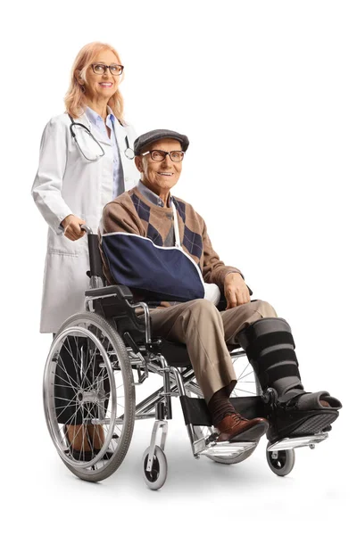 Full length shot of a female doctor and an injured mature patient in a wheelchair isolated on white background 
