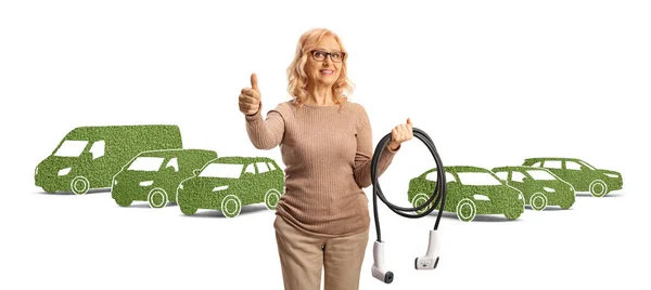 Woman Holding Cables Charging Gesturing Thumbs Front Green Vehicles Isolated — Stock Photo, Image