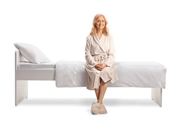 Donna Matura Accappatoio Dorme Seduta Letto Sorridente Isolata Sfondo Bianco — Foto Stock
