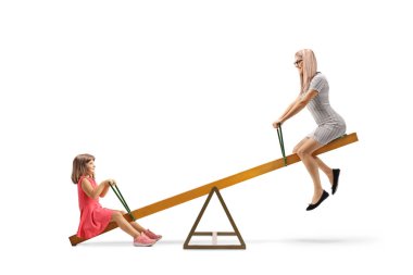 Anne ve kızı, beyaz arka planda izole edilmiş bir tahterevallinin üzerinde sallanıyorlar.