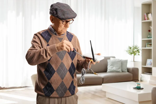 Yaşlı Bir Adam Evde Oturma Odasında Tornavidayla Yönlendirici Tamir Ediyor — Stok fotoğraf