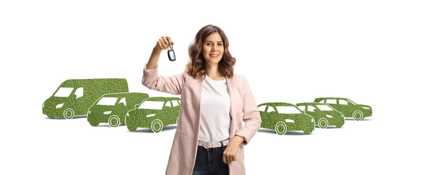 Junge Frau Mit Autoschlüssel Vor Grünen Elektrofahrzeugen Auf Weißem Hintergrund — Stockfoto