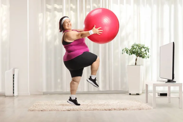 Избыточный Вес Женщина Упражнения Фитнес Мяч Перед Телевизором Дому — стоковое фото
