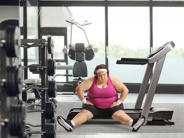Utmattad Överviktig Kvinna Sitter Ett Löpband Ett Gym — Stockfoto