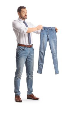 Düşünceli adam beyaz sırtlı, dar bir kot pantolona bakıyor.