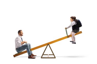 Baba ve kızı beyaz arka planda izole edilmiş bir tahterevallide oynuyorlar.