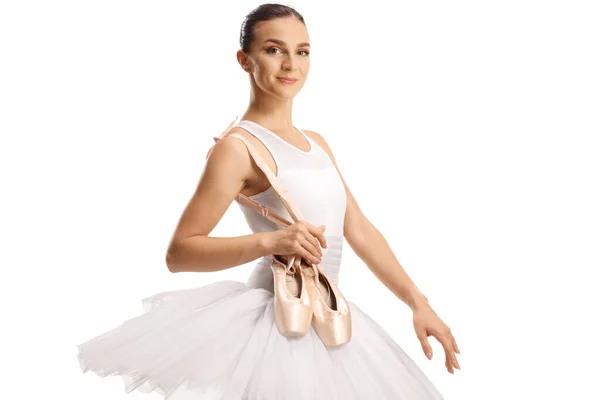 芭蕾舞蹈演员举着她的脚尖鞋 在白色的背景下面带微笑 — 图库照片
