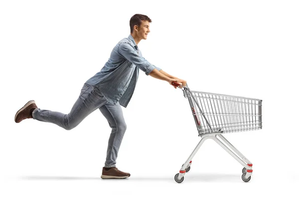 Beyaz Arka Planda Boş Bir Alışveriş Arabasıyla Koşan Bir Gencin — Stok fotoğraf