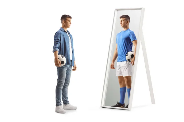 抱着足球希望成为职业球员的家伙 看着镜子里被白色背景隔离的人 — 图库照片
