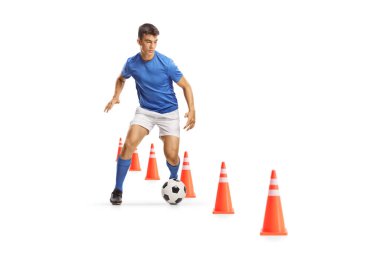 Beyaz zemin üzerinde izole edilmiş antrenman konilerinin arasından top koşan ve liderlik eden futbolcu