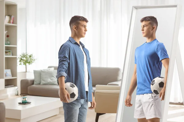 Mladý Muž Drží Fotbal Dívá Sebe Jako Fotbalista Zrcadle Doma — Stock fotografie