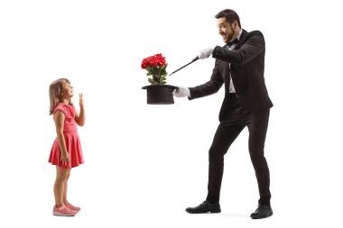 Full length profile shot of a girl watching a magician performing a trick isolated on white backgroun clipart