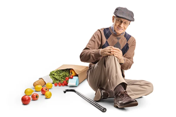 Starší Muž Taškou Potravinami Sedí Podlaze Drží Své Bolestivé Koleno — Stock fotografie
