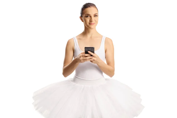 身着白色连衣裙的芭蕾舞演员拿着智能手机 看着被白色背景隔离的相机 — 图库照片