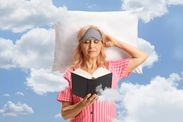 Γυναίκα Αναπαύεται Ένα Μαξιλάρι Στα Σύννεφα Και Διαβάζει Ένα Βιβλίο — Φωτογραφία Αρχείου
