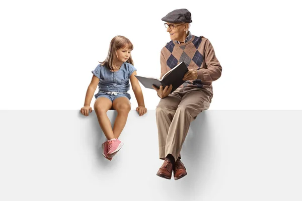 Avô Lendo Livro Para Uma Menina Sentado Painel Branco Isolado — Fotografia de Stock