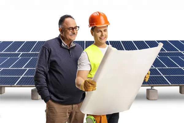 Construction worker showing a solar farm plan to a mature man isolated on white background
