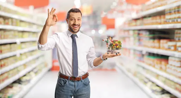 Junger Geschäftsmann Mit Kleinem Einkaufswagen Mit Lebensmitteln Der Hand Und — Stockfoto