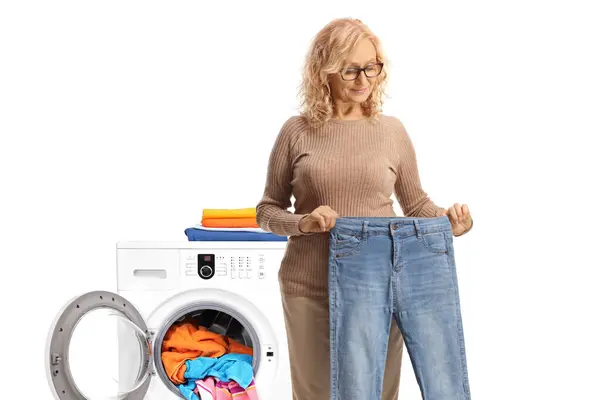 Kvinna Som Tar Ett Par Jeans Tvättmaskin Isolerad Vit Rygg — Stockfoto