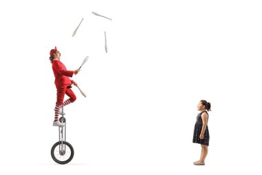 Girl watching an acrobat riding a giraffe unicycle and juggling isolated on white background clipart