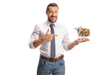 Elinde yiyecek ve beyaz arka planda izole edilmiş küçük bir alışveriş arabası tutan genç adam.