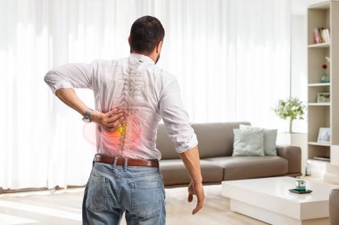 Sırtı ağrıyan bir adamın oturma odasında dikiz görüntüsü.