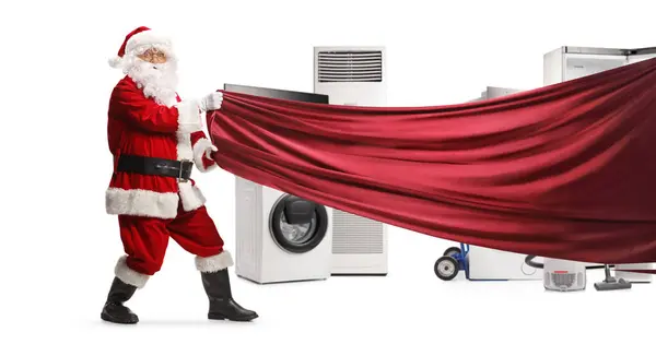 サンタクロースは白い背景に隔離された家電の前に赤いカーテンを引っ張ります — ストック写真
