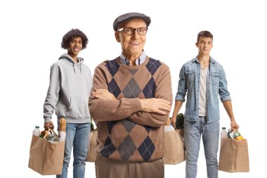 Genç erkeklerin önünde poz veren yaşlı bir adam beyaz arka planda izole edilmiş alışveriş torbalarıyla